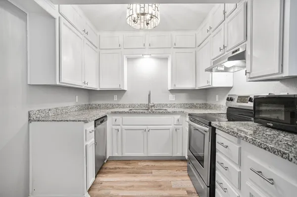 a kitchen with stainless steel appliances granite countertop a sink stove and cabinets