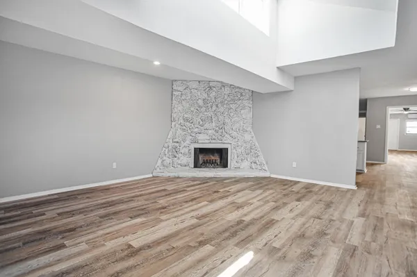 a view of an empty room with a fireplace and a window