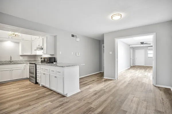 a kitchen with granite countertop cabinets stainless steel appliances a sink and a window
