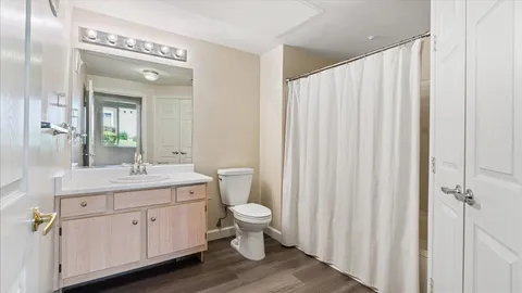 a bathroom with a double vanity sink toilet and a mirror