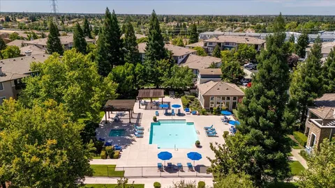 an aerial view of residential houses with outdoor space and trees