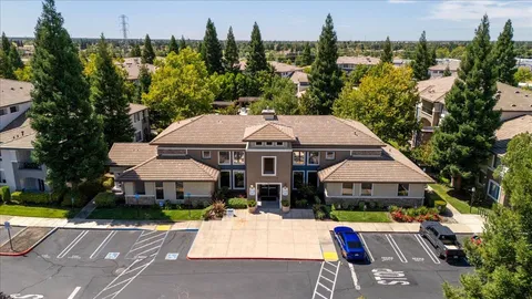 an aerial view of a house with swimming pool and a chairs