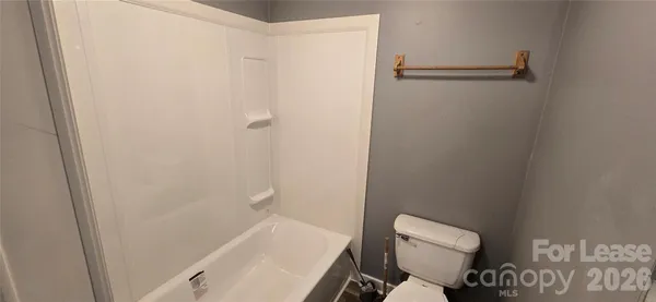 a white toilet sitting next to a shower