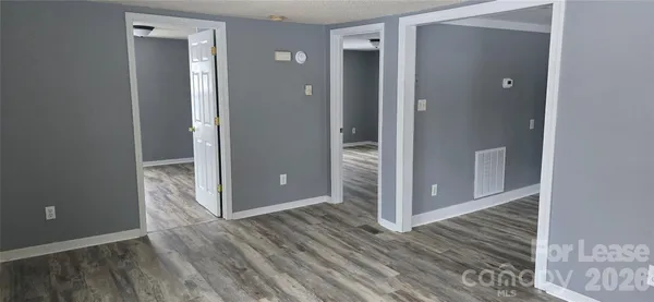 an empty room with wooden floor and entrance