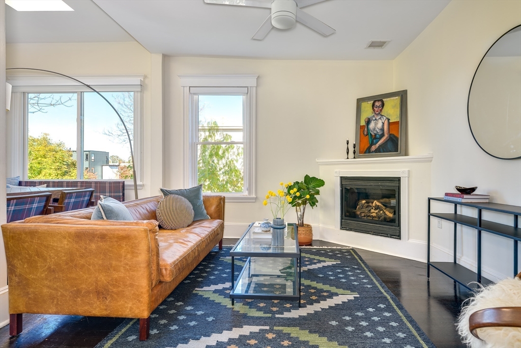 161 Columbia Street, Unit 3 Cambridge, MA 02139 - Photo 2 of 19 a living room with furniture a large window and a fireplace