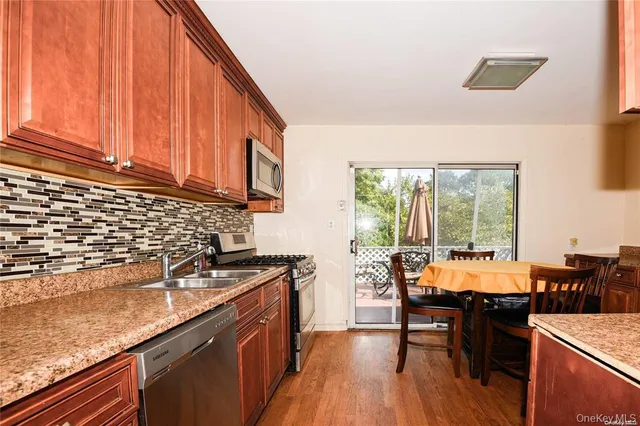 a kitchen with a sink a counter top space and stainless steel appliances
