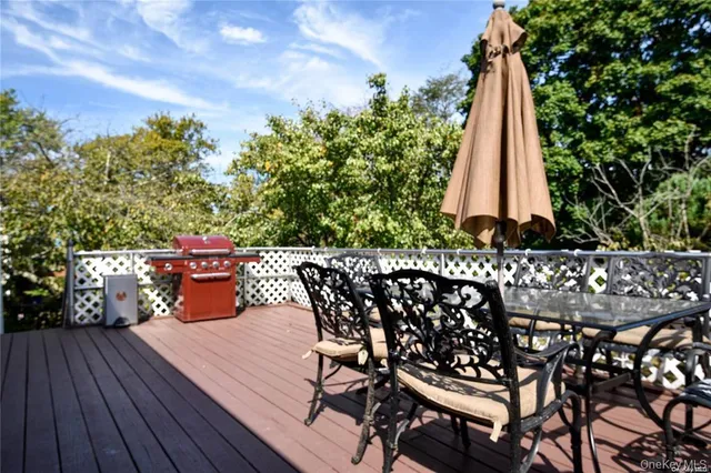 a view of a chairs and table on the wooden roof deck
