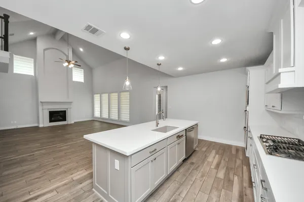 a large white kitchen with sink and refrigerator