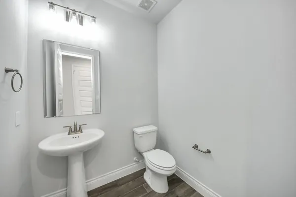 a bathroom with a sink a toilet and mirror