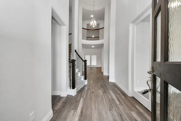 a view of a hallway with wooden floor and staircase