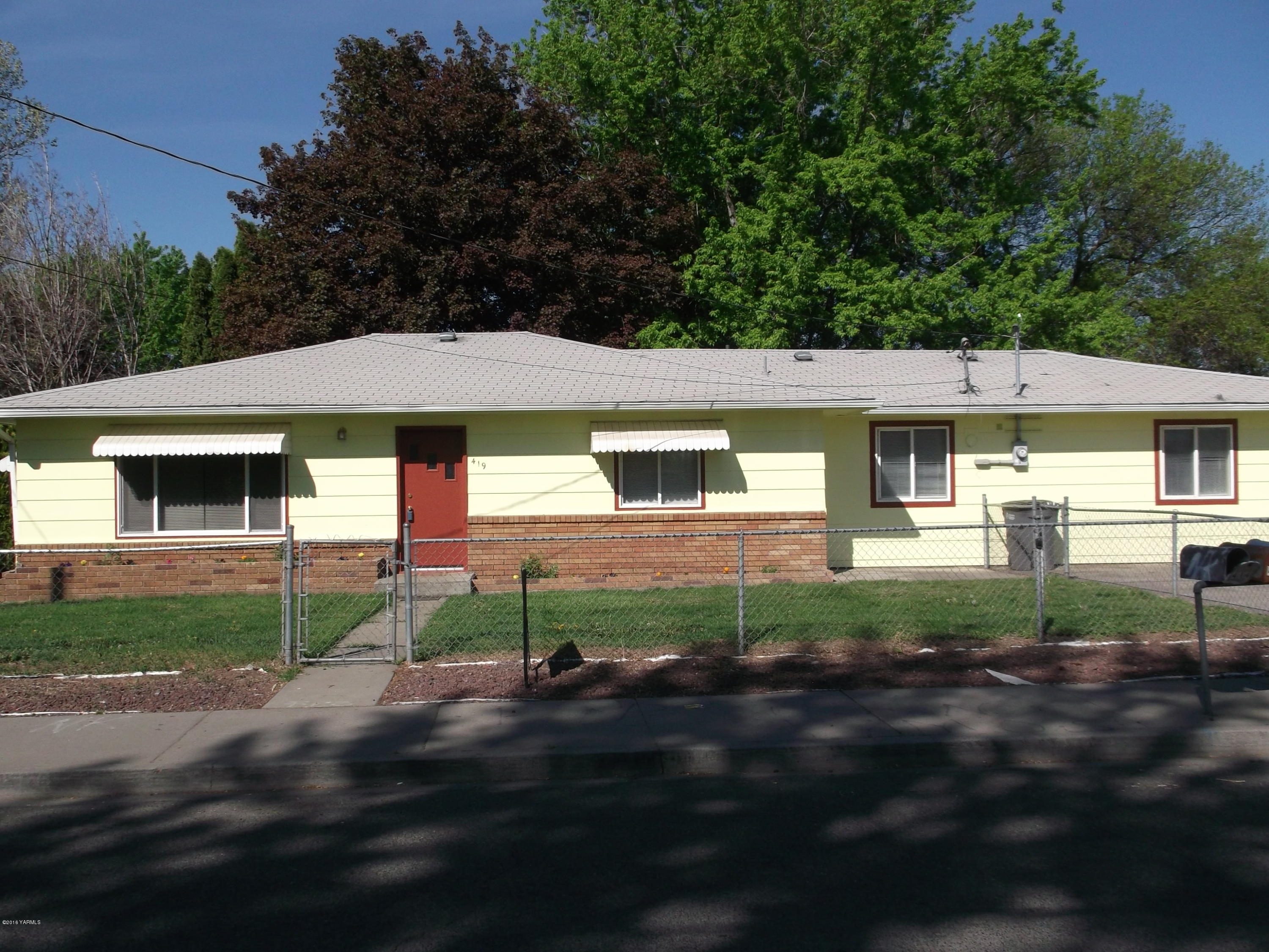 a front view of a house with yard and green space