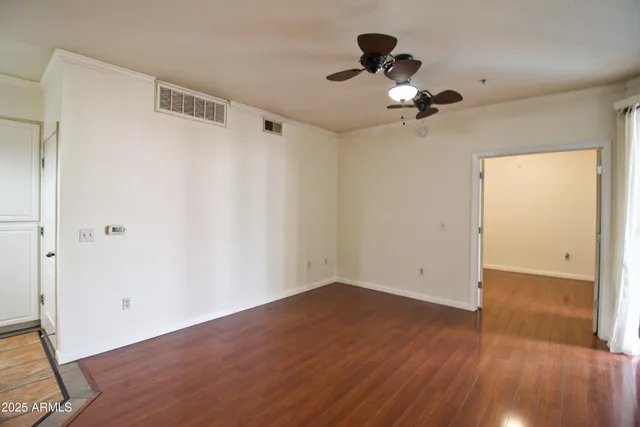 a view of empty room with wooden floor