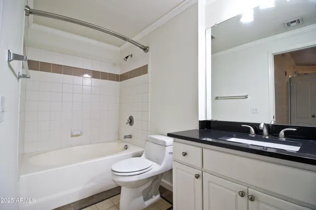 a bathroom with a granite countertop sink a toilet a mirror and bathtub