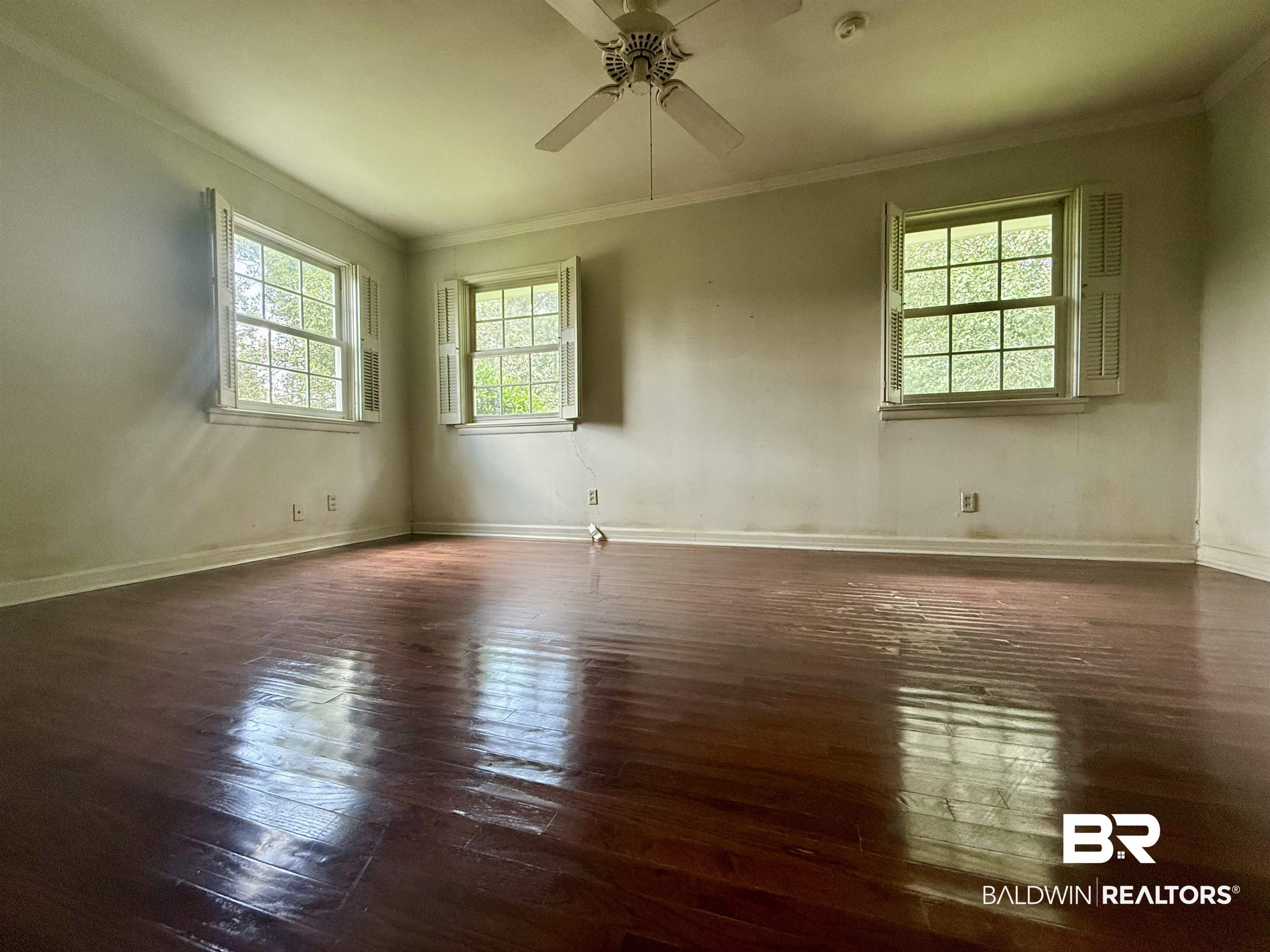 1412 Poplar Avenue Brewton, AL 36426 - Photo 19 of 32 Spare room with ceiling fan, crown molding, hardwood / wood-style flooring, baseboards, and a smoke detector