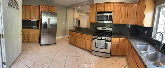 a kitchen with stainless steel appliances granite countertop a refrigerator and a stove