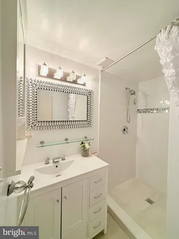 a bathroom with a sink a mirror and a shower