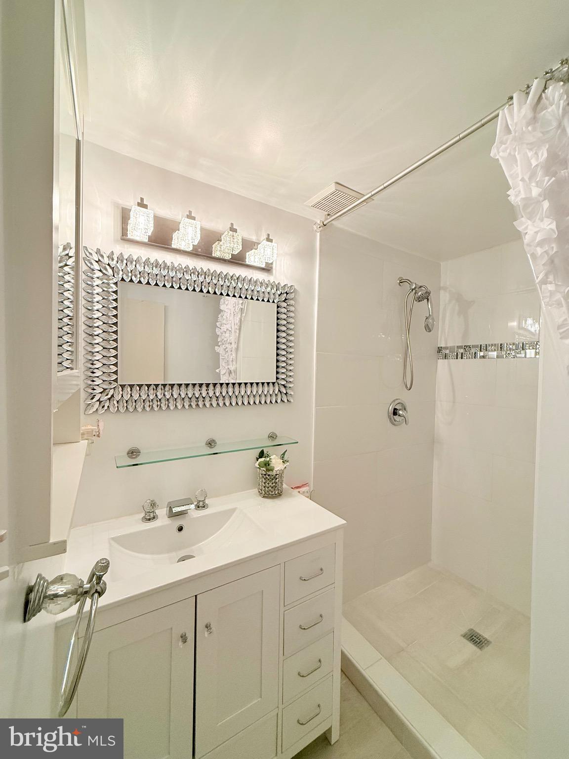 6915 Bugledrum Way Columbia, MD 21045 - Photo 14 of 25 a bathroom with a sink a mirror and a shower