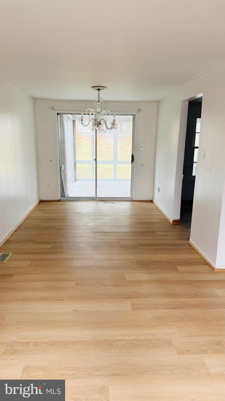 6915 Bugledrum Way Columbia, MD 21045 - Photo 5 of 25 a view of an empty room with wooden floor and a window