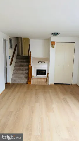 a view of an empty room with fireplace and a window