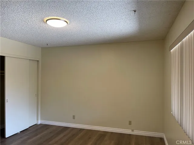 an empty room with wooden floor and closet