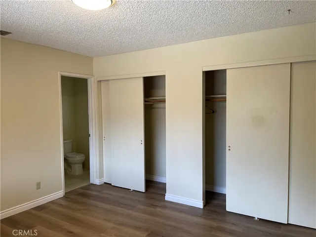 a bathroom with a granite countertop sink toilet and mirror