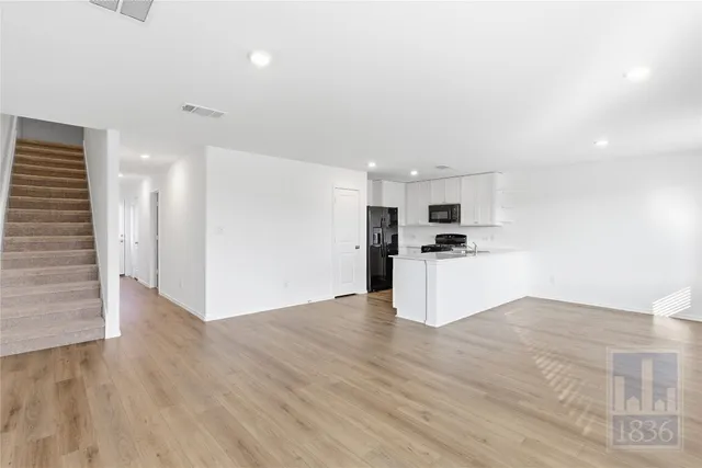 a view of kitchen with granite countertop cabinets and refrigerator