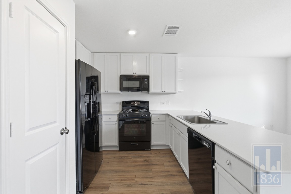 2213 Cyclone Drive Lockhart, TX 78644 - Photo 7 of 26 a kitchen with a sink a stove and refrigerator