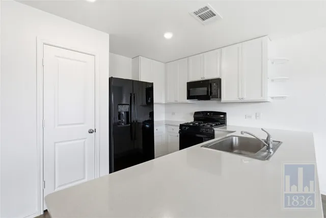 a kitchen with a refrigerator and a stove top oven