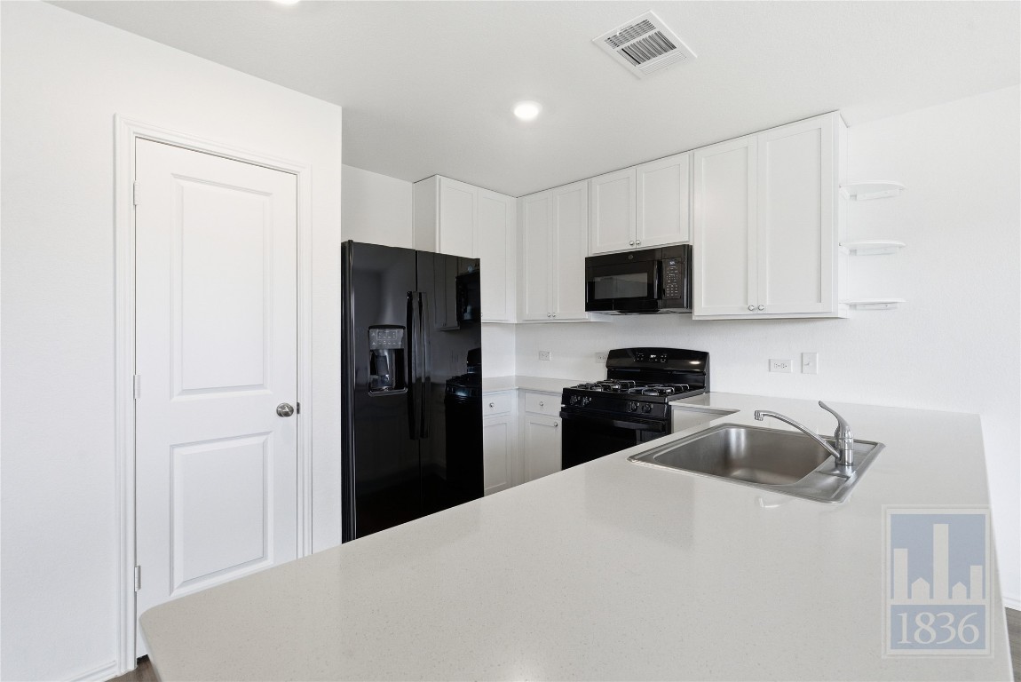 2213 Cyclone Drive Lockhart, TX 78644 - Photo 8 of 26 a kitchen with a refrigerator and a stove top oven