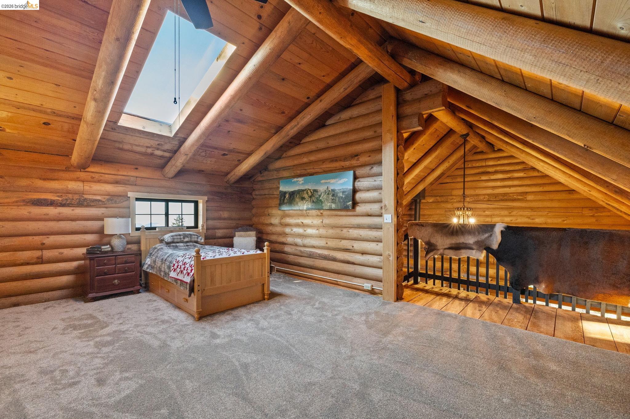 16144 Big Hill Road Sonora, CA 95370 - Photo 29 of 51 Carpeted loft space featuring log wall construction and exposed wood beams