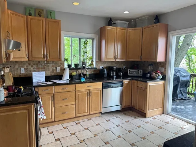 a kitchen with stainless steel appliances a sink window and cabinets