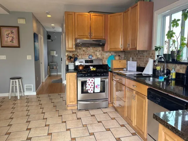 a kitchen with stainless steel appliances granite countertop a stove a sink and a refrigerator