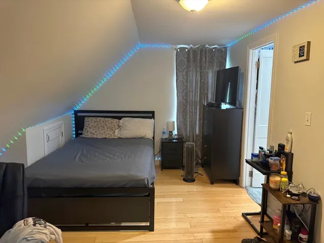 a bedroom with a bed and wooden floor