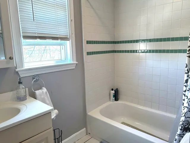 a white bath tub sitting next to a white sink and vanity
