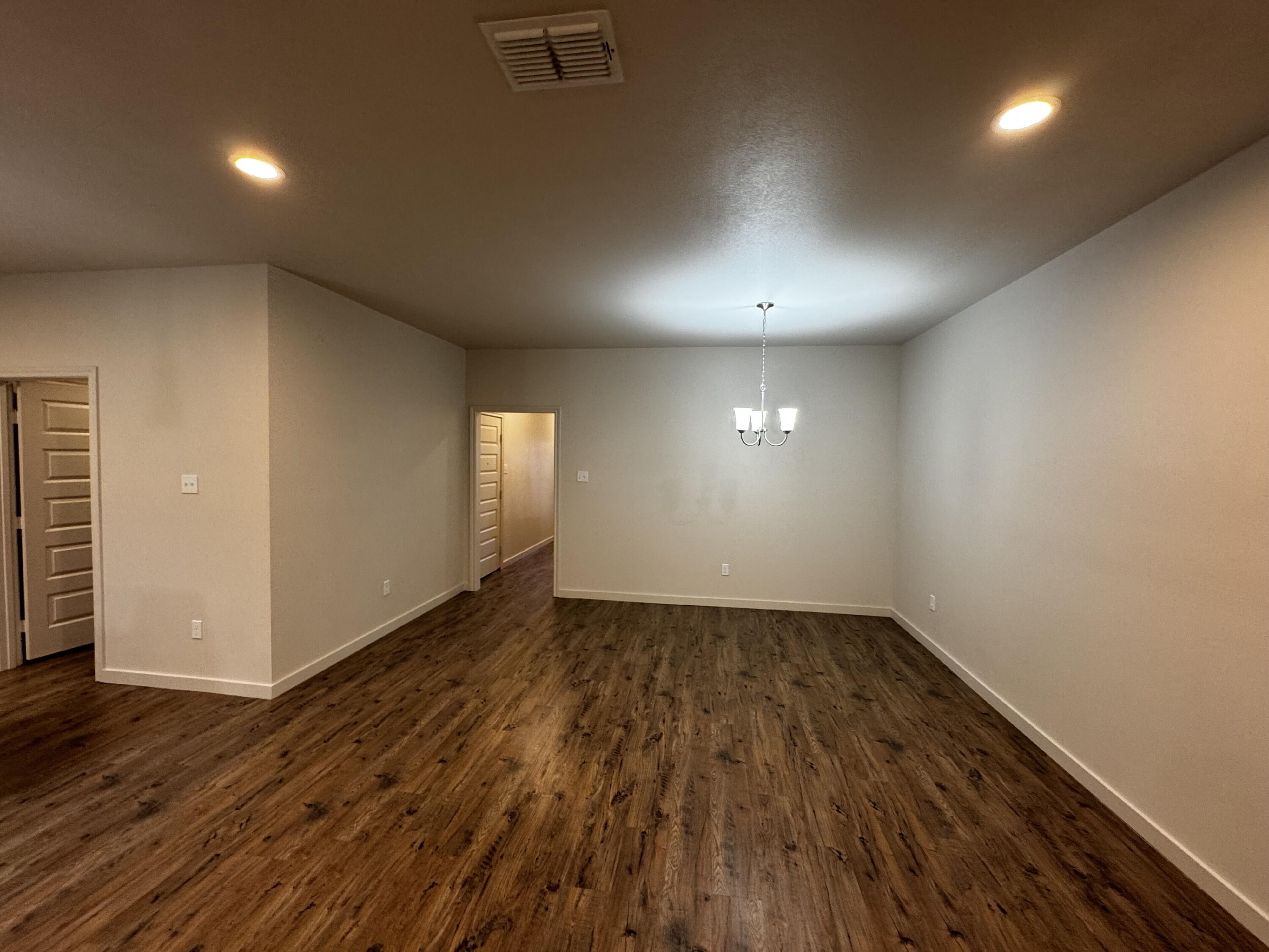 2613 135th Street Lubbock, TX 79423 - Photo 3 of 15 an empty room with wooden floor and windows