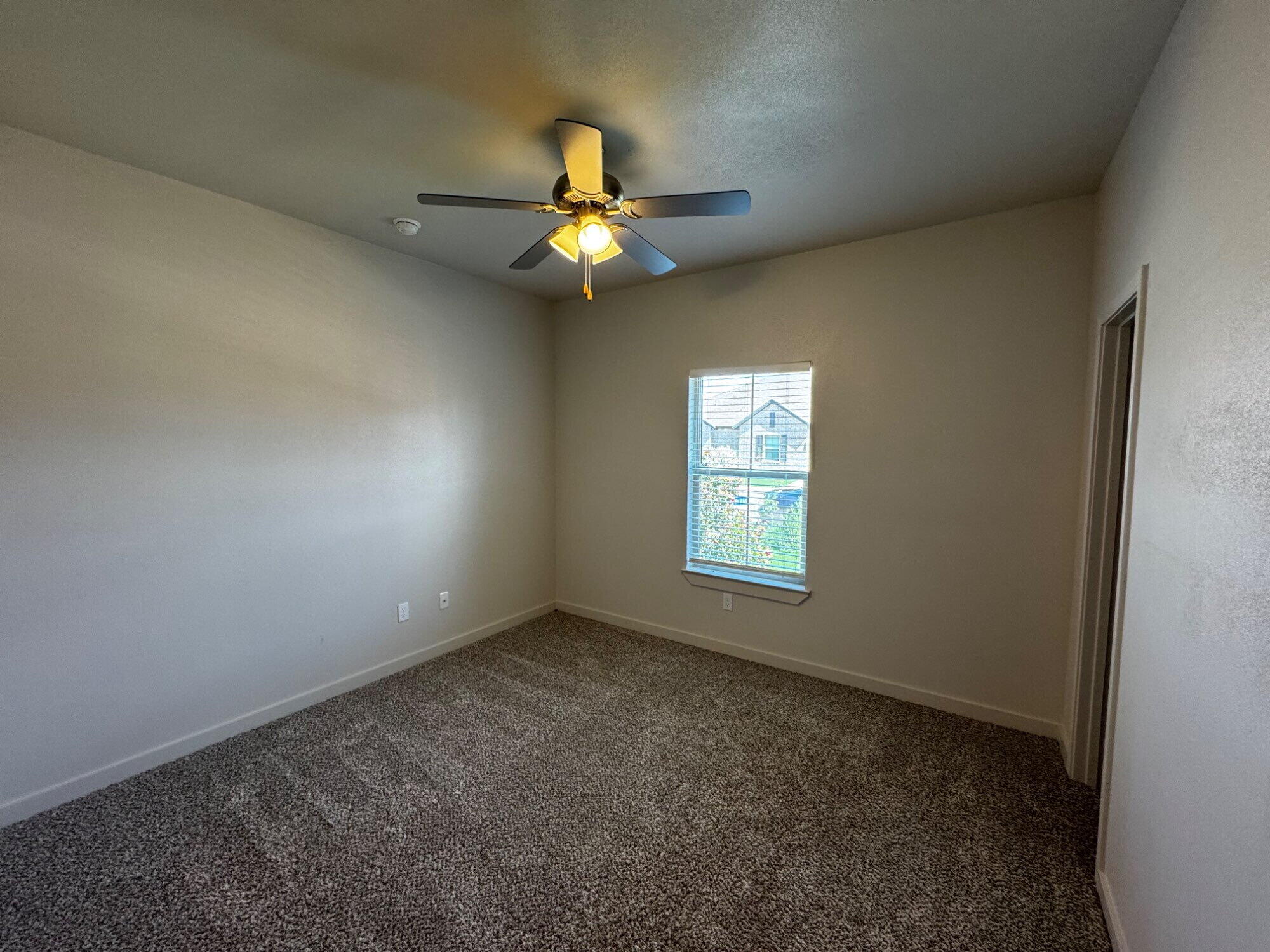 2613 135th Street Lubbock, TX 79423 - Photo 8 of 15 an empty room with windows and fan