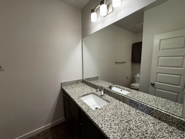 a bathroom with a granite countertop sink and a mirror