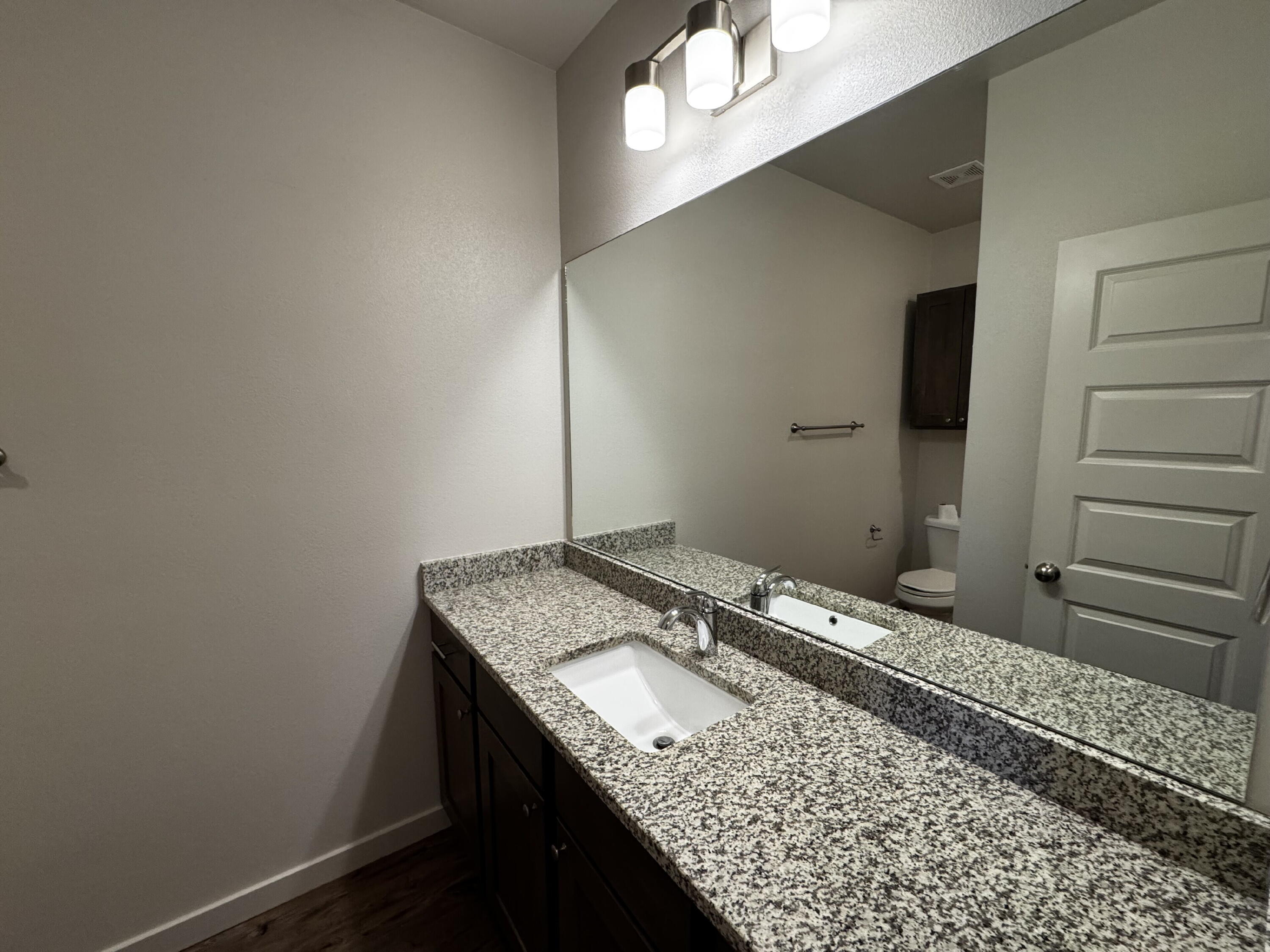 2613 135th Street Lubbock, TX 79423 - Photo 9 of 15 a bathroom with a granite countertop sink and a mirror