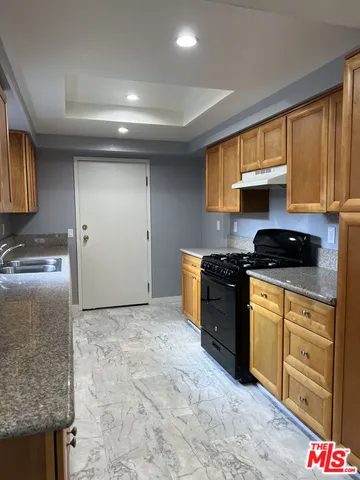 a kitchen with stainless steel appliances granite countertop a stove a sink and a refrigerator