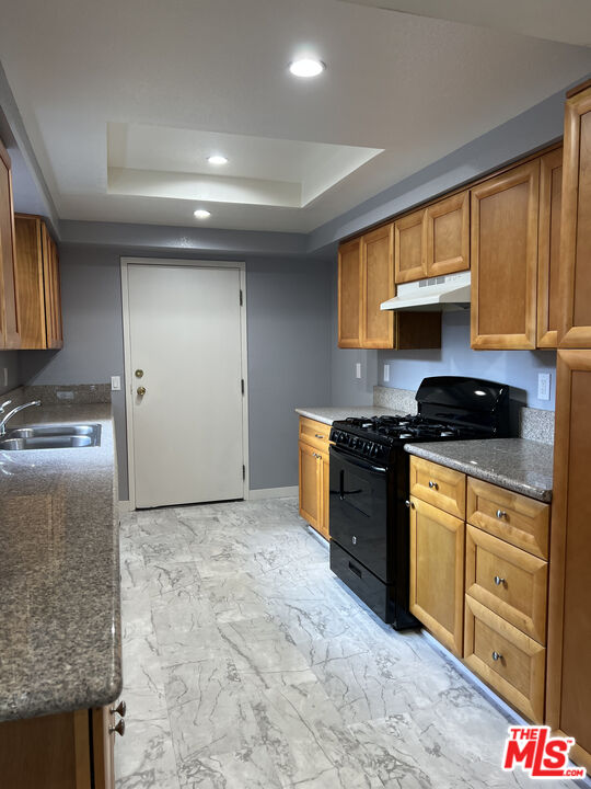 7639 Kester Avenue, Unit 5 Van Nuys, CA 91405 - Photo 2 of 21 a kitchen with stainless steel appliances granite countertop a stove a sink and a refrigerator