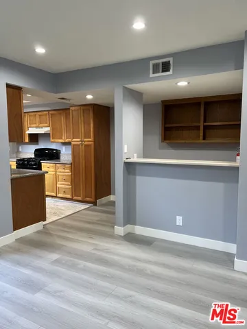 a kitchen with stainless steel appliances kitchen island granite countertop a refrigerator and a stove top oven