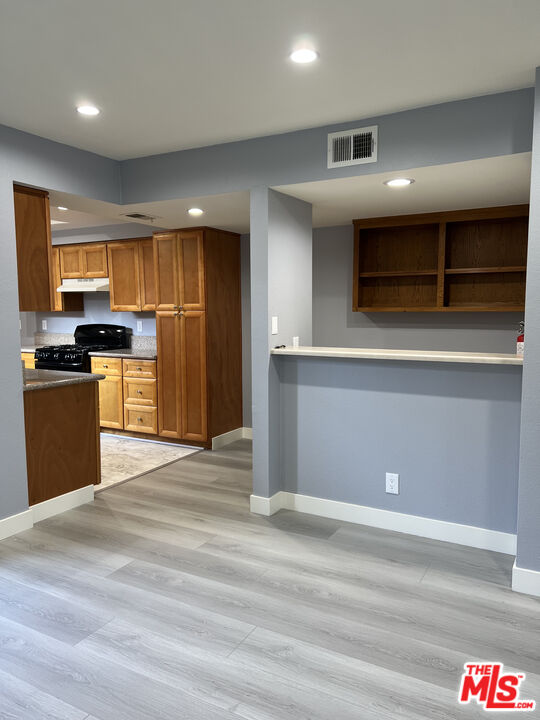 7639 Kester Avenue, Unit 5 Van Nuys, CA 91405 - Photo 5 of 21 a kitchen with stainless steel appliances kitchen island granite countertop a refrigerator and a stove top oven