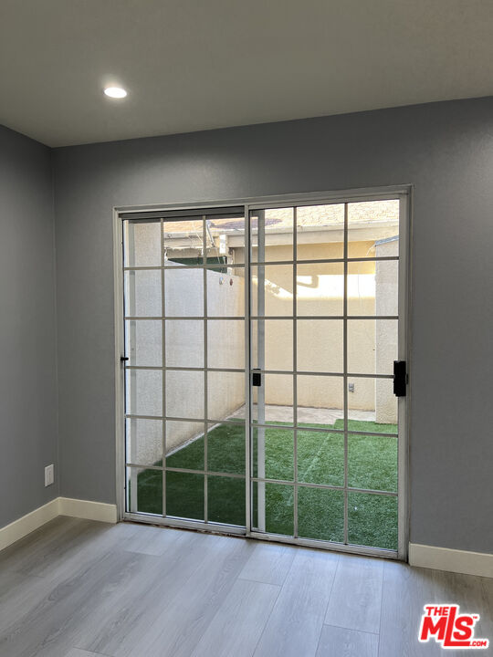 7639 Kester Avenue, Unit 5 Van Nuys, CA 91405 - Photo 6 of 21 a view of an empty room with wooden floor and a window