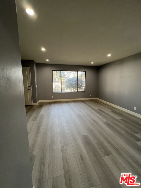 7639 Kester Avenue, Unit 5 Van Nuys, CA 91405 - Photo 9 of 21 an empty room with wooden floor and windows