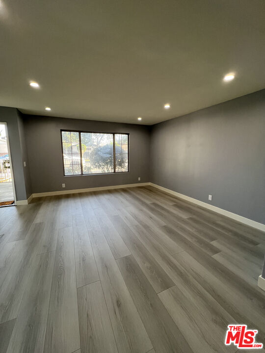 7639 Kester Avenue, Unit 5 Van Nuys, CA 91405 - Photo 10 of 21 an empty room with wooden floor and windows