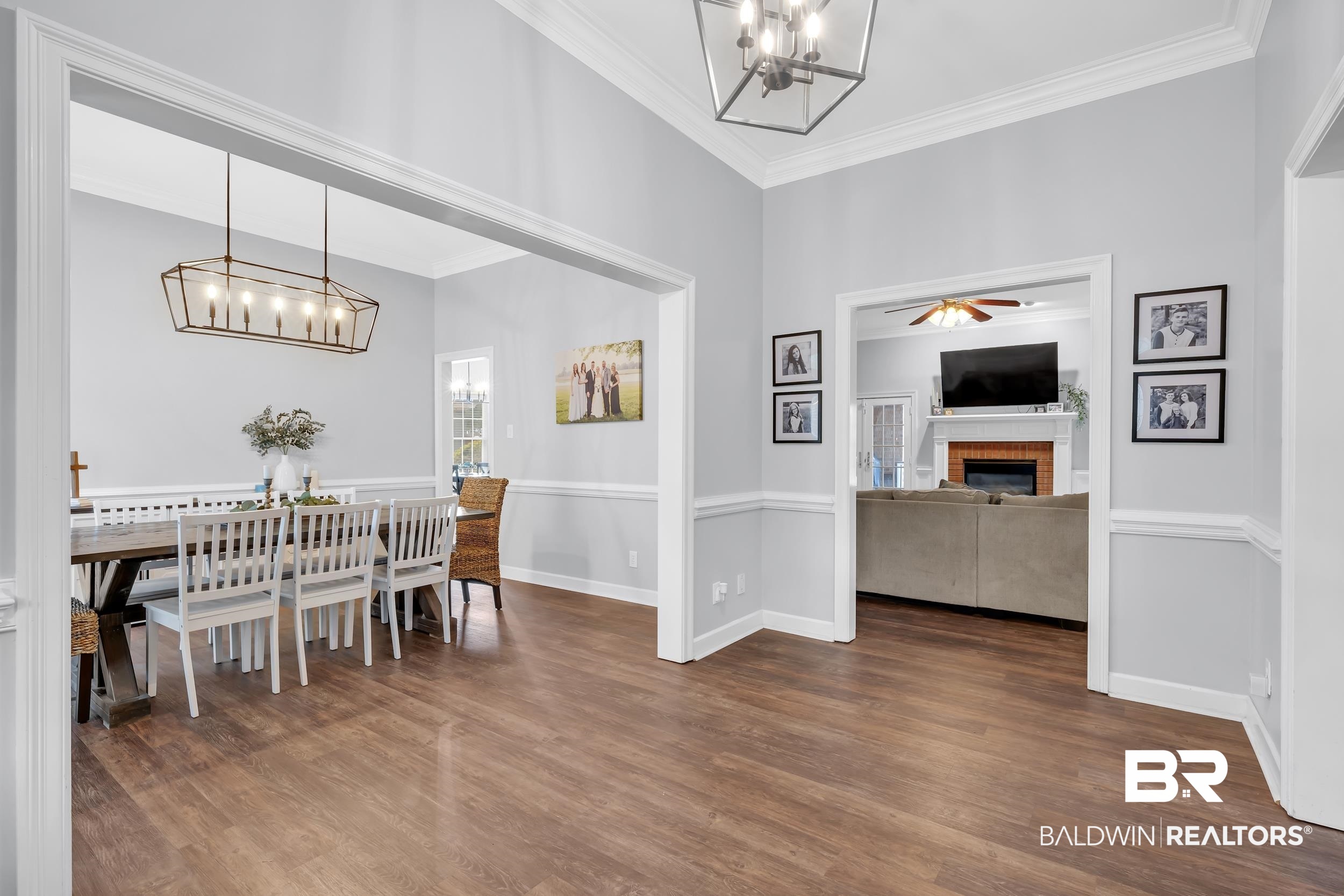 2858 Postoak Circle Mobile, AL 36693 - Photo 10 of 32 Dining room with a chandelier, a brick fireplace, dark wood finished floors, crown molding, and a ceiling fan