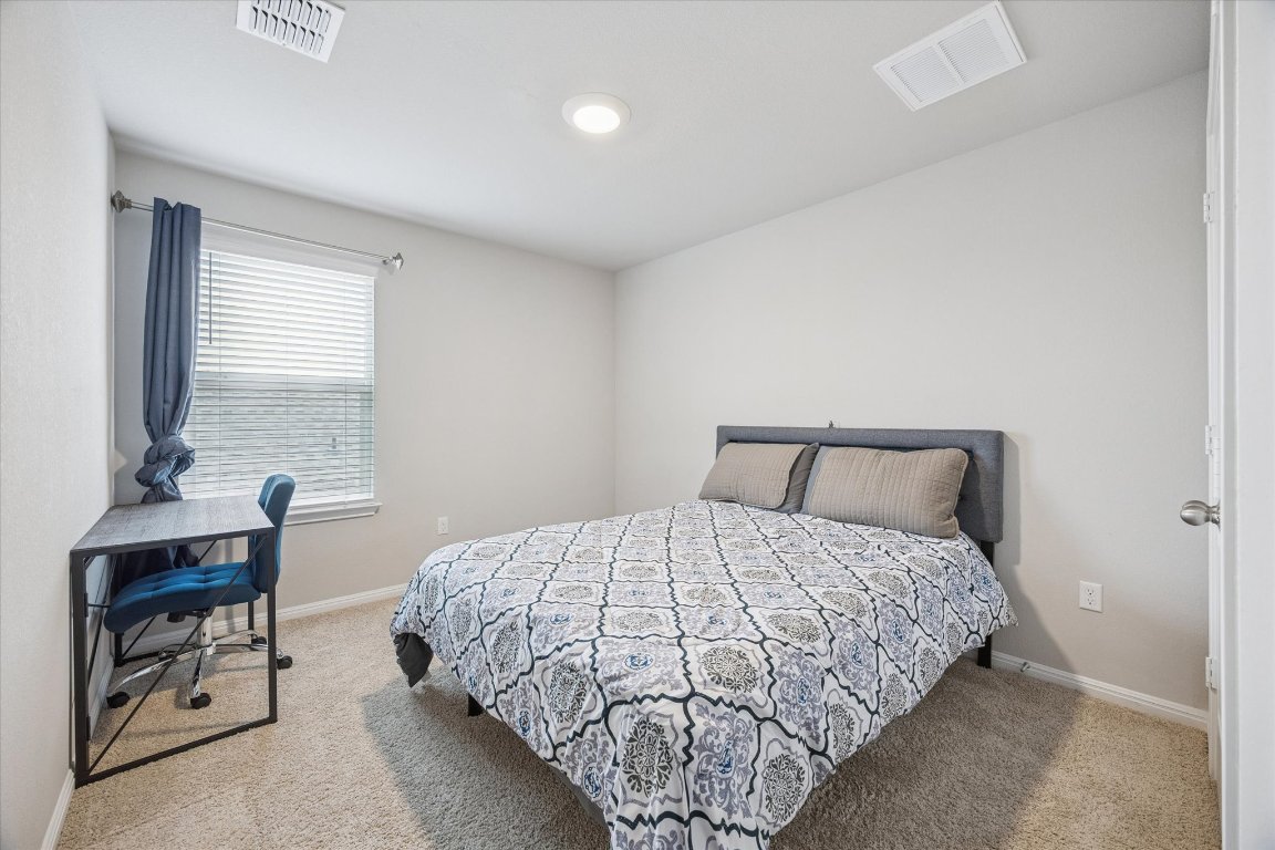 724 Aster Place Bastrop, TX 78602 - Photo 12 of 16 a bedroom with a bed and a table