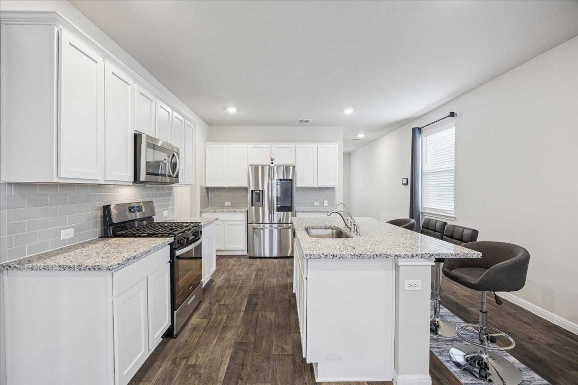 724 Aster Place Bastrop, TX 78602 - Photo 4 of 16 a kitchen with stainless steel appliances granite countertop a sink stove and refrigerator