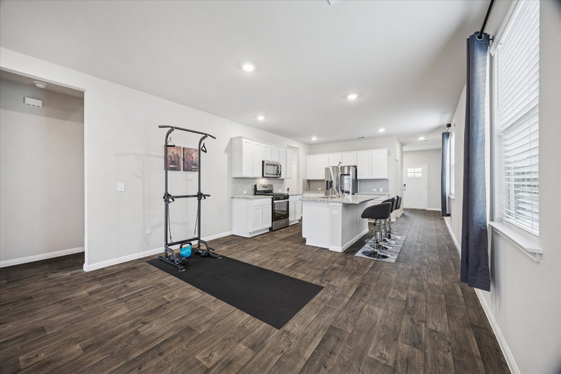 724 Aster Place Bastrop, TX 78602 - Photo 7 of 16 a living room with stainless steel appliances kitchen island granite countertop a refrigerator and a sink