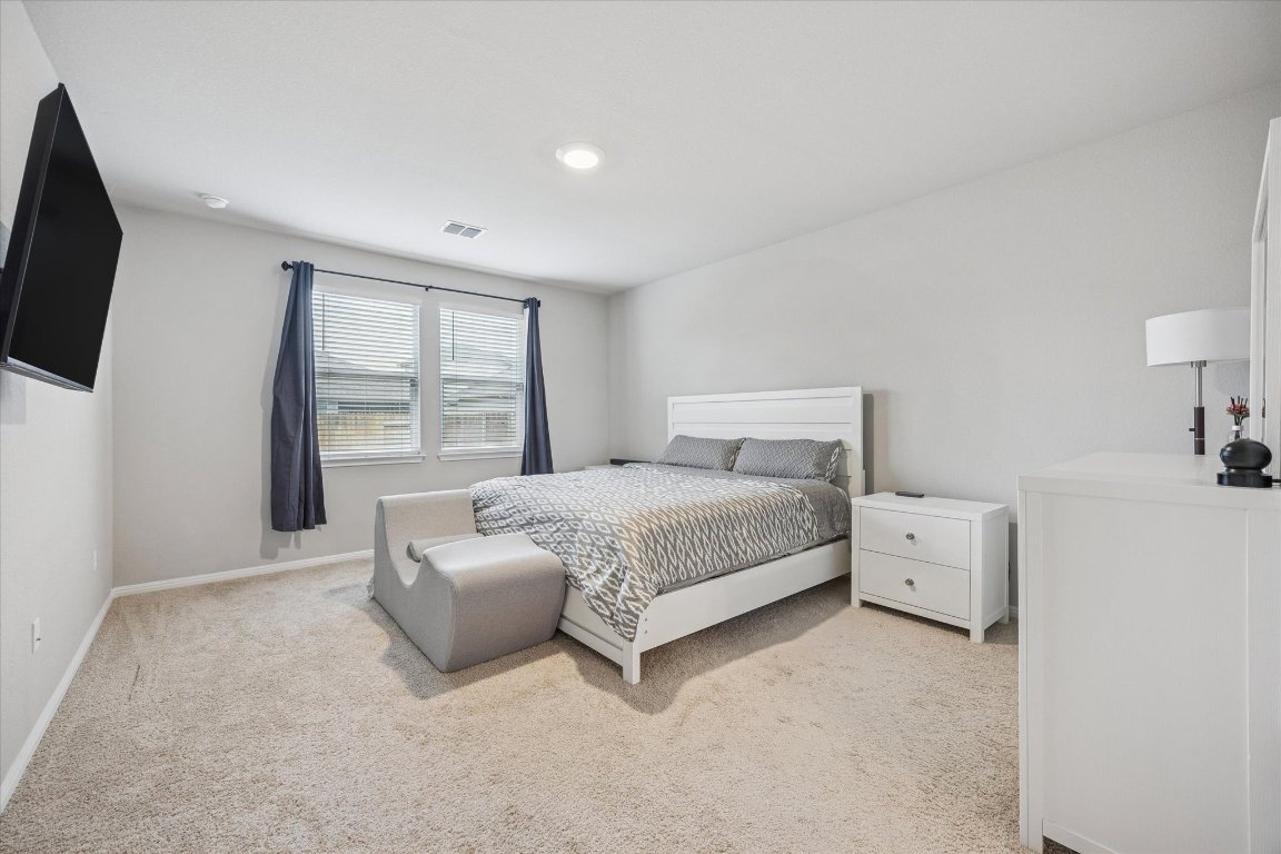 724 Aster Place Bastrop, TX 78602 - Photo 8 of 16 a bedroom with a bed and a flat screen tv